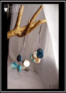 Paire de boucles d'oreilles, crochet acier. Six perles plates en verre imitation nacre, bleu, blanc et bleu foncé chacune au bout d'un fil synthétique rigide. Longueur 6,5 cm