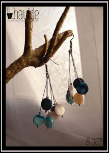 Paire de boucles d'oreilles, crochet acier. Six perles plates en verre imitation nacre, bleu, blanc et bleu foncé chacune au bout d'un fil synthétique rigide. Longueur 6,5 cm