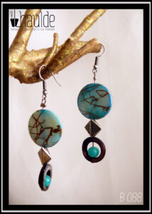 Paire de boucles d'oreilles. Crochet acier. Perles en nacre, verre et acier montées sur tige acier. Perle plate en nacre bleu marbré de doré, perle creuse circulaire en nacre gris avec au centre une perle ronde en verre opaque bleu,. Longueur 6,7 cm