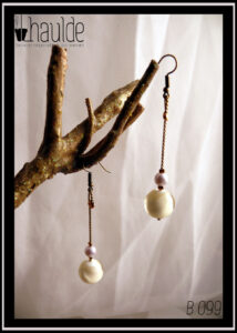 paire de boucles d'oreilles, crochets acier doré, perle en verre au bout d'une chaine tressée en acier doré surmontée d'une petite perle en nacre synthétique légèrement mauve. Longueur 7 cm