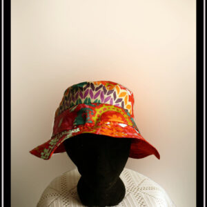 Mannequin tête vue de face portant un bob rouge à motifs multicolore de type fleurs stylisées et points de tricot