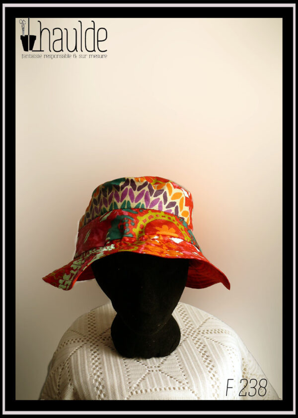 Mannequin tête vue de face portant un bob rouge à motifs multicolore de type fleurs stylisées et points de tricot