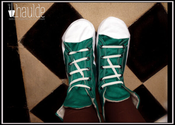 Paire de chaussons façon sneakers vert et blanc vus de dessus, portés