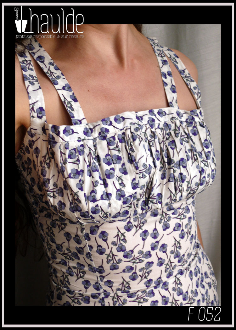 Robe d'été à double bretelles en batiste imprimée pensées violettes et mauves, buste plissé, taille ajustée, jupe ample. Vue de face, portée, jusqu'à la taille