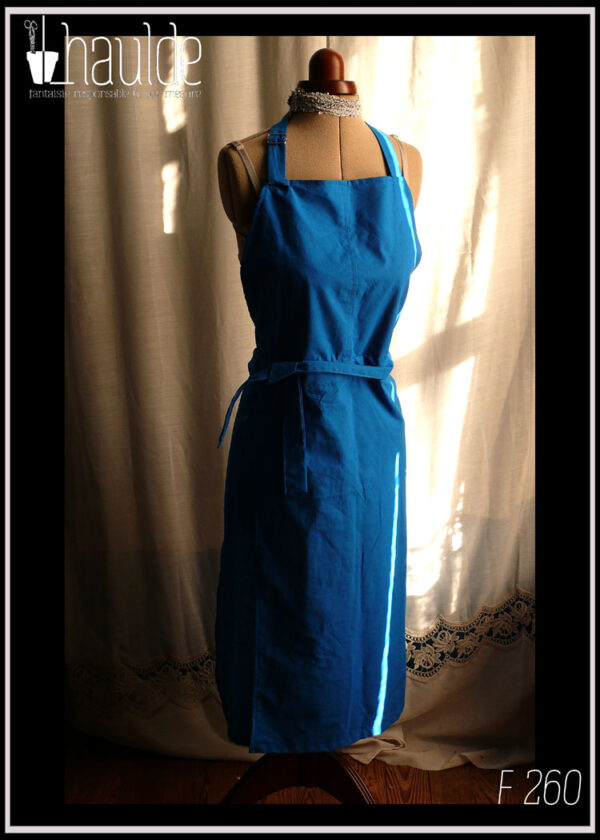 Tablier de potier (deux pans fendus pour les jambes) en toile légère bleu électrique, ceinture longue pouvant se nouer à l'avant. Vu de face sur un mannequin de couture