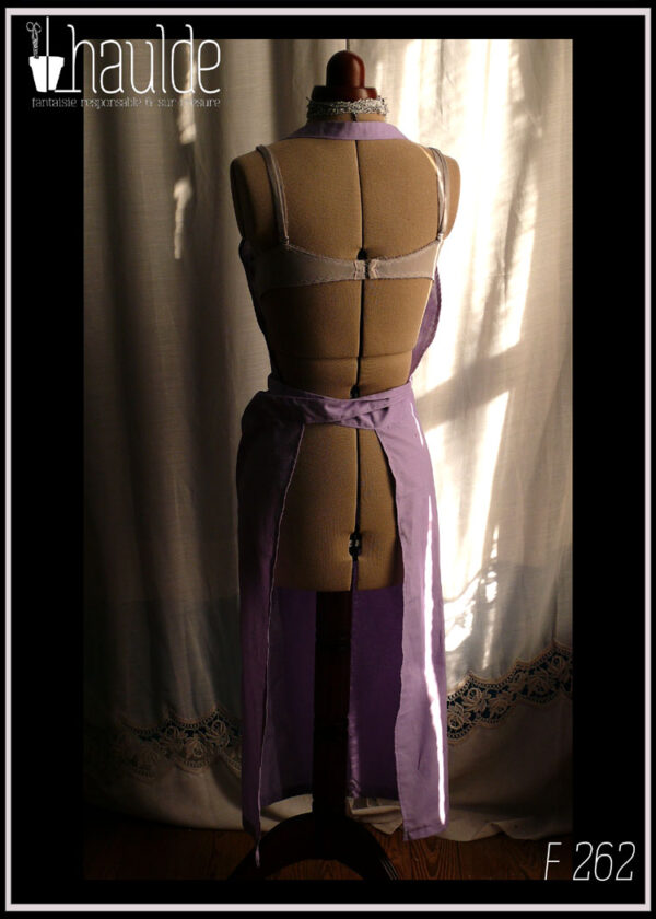 Tablier de potier (deux pans fendus pour les jambes) en toile légère mauve, ceinture longue pouvant se nouer à l'avant. Vu de dos sur un mannequin de couture