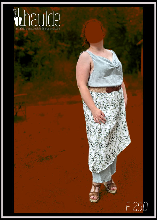 femme debout de trois quarts visage masqué portant une combinaison sans manches couverte d'une sur jupe