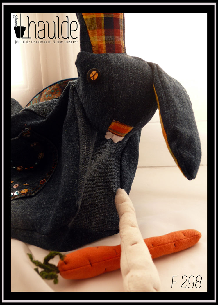 sac en forme de lapin en jean sombre vu de trois quarts face avec des carottes en tissu