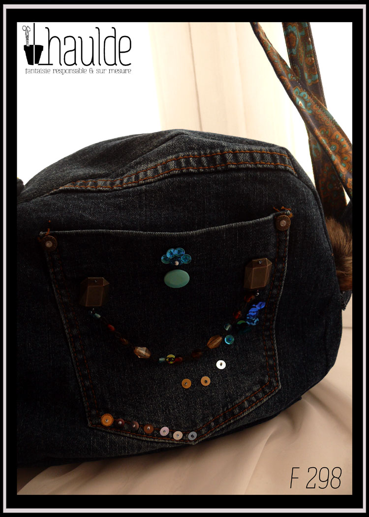 sac en forme de lapin en jean sombre, détail de la poche extérieure gauche, poche arrière de jeans avec une pression bleu pâle et des sequins brodés. Une chainette de perles de verre court d'un bout à l'autre de la poche