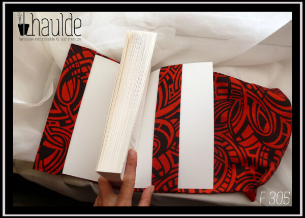 Protège livre en tissu rouge et noir, motifs abstraits, courbes parallèles Vu ouvert avec le rabat et la bande centrale