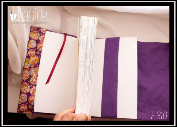 Protège livre en tissu violet imprimé temari (balles brodées japonaises) multicolores Vu ouvert avec le rabat, le marque page pourpre, la bande centrale violette