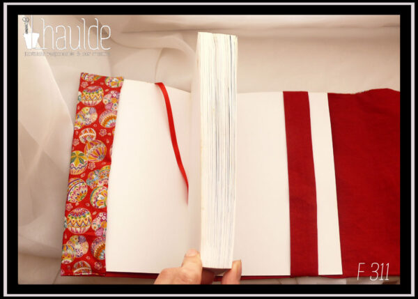 Protège livre en tissu rouge imprimé temari (balles brodées japonaises) multicolores Vu ouvert avec le rabat, le signet en satin rouge et la bande centrale
