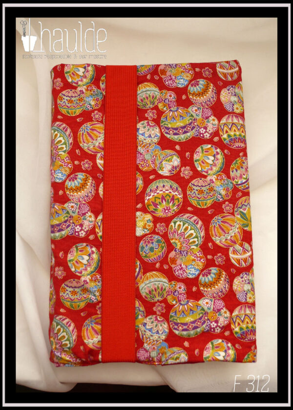 Protège livre en tissu rouge imprimé temari (balles brodées japonaises) multicolores Vu fermé par son gros élastique rouge