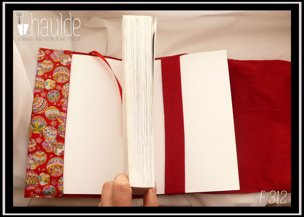 Protège livre en tissu rouge imprimé temari (balles brodées japonaises) multicolores Vu ouvert avec le rabat, le signet en satin rouge et la bande centrale