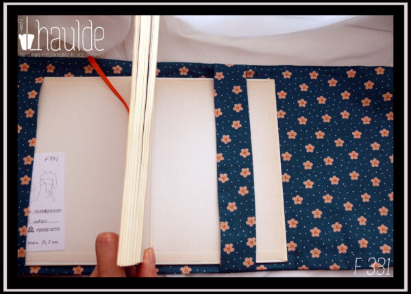 Protège-livre en coton vert foncé imprimé petites fleurs orange pâle et points blancs, vu ouvert, intérieur dans le même tissu, signet orange