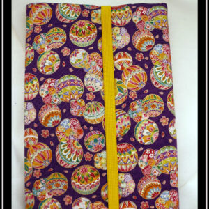 Protège livre en tissu violet imprimé temari (balles brodées japonaises) multicolores Vu fermé par un élastique jaune
