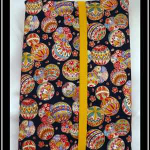 Protège livre en tissu bleu marine très foncé imprimé temari (balles brodées japonaises) multicolores Vu fermé par un élastique jaune