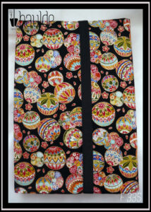 Protège livre en tissu noir imprimé temari (balles brodées japonaises) multicolores Vu fermé par un élastique noir