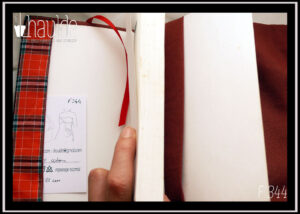 Protège livre en tissus à carreaux écossais rouges vif (lignes noires et grises) vu ouvert, signet en satin rouge, doublure en coton marron