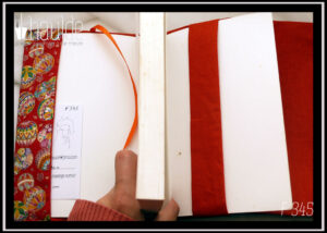 Protège livre en tissu rouge imprimé temari (balles brodées japonaises) multicolores Vu ouvert, signet en satin orange, doublure orange foncé