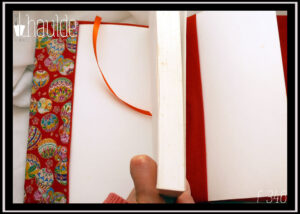 Protège livre en tissu rouge imprimé temari (balles brodées japonaises) multicolores Vu ouvert, signet en satin orange, doublure orange foncé