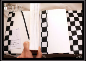 Protège-livre damier, à carreaux noirs et blancs, vu ouvert, signet en satin noir, doublure dans le même tissu à damier