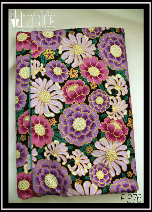Protège livre en tissu noir imprimé grosses fleurs mauves, violettes et roses, avec du doré Vu fermé