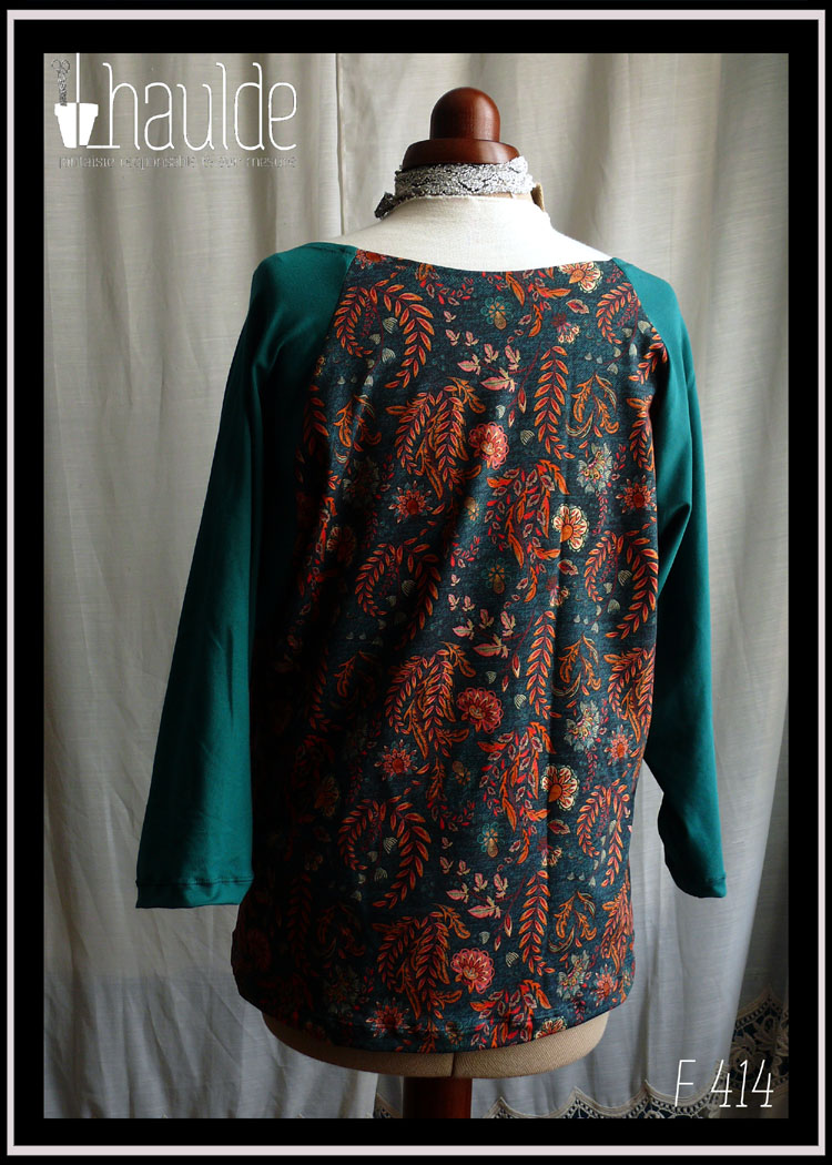 Haut manches longues encolure dégagée, centre devant et dos en tissu bleu mariné imprimé feuilles d'automne et fleurs (dominante orange foncé, bleu et rose) et manches vert canard Vu de dos sur un mannequin de couture