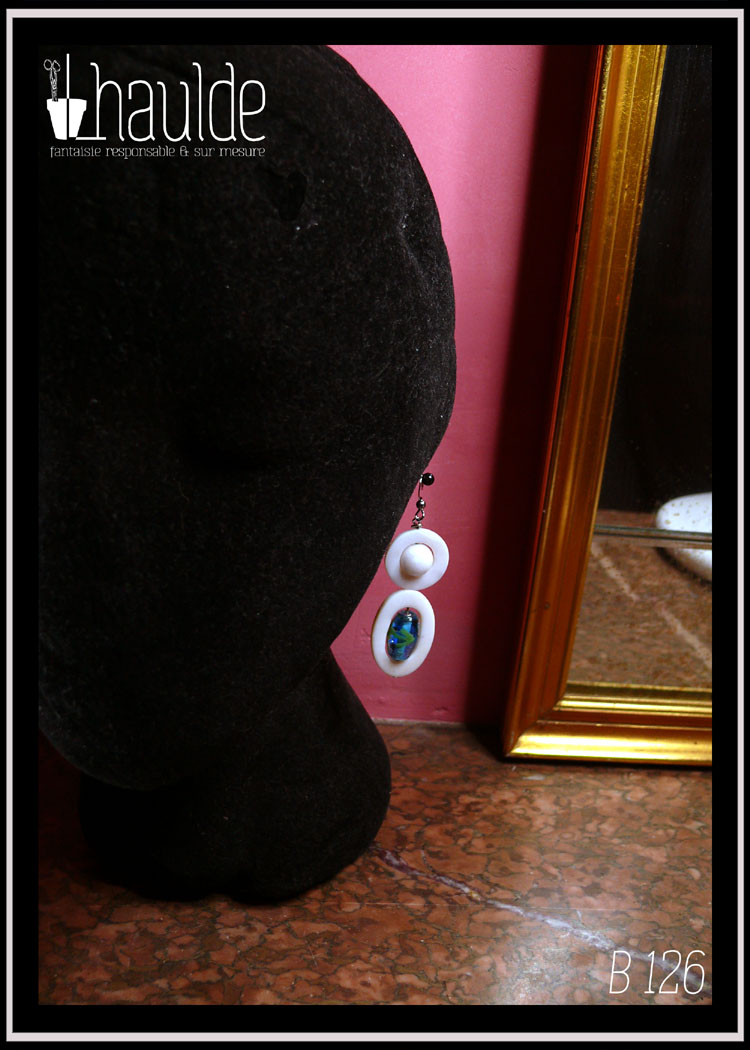 boucles d'oreilles montées sur crochet d'acier et composées d'une ellipse de nacre blanc avec en son centre une perle en verre de Bohème identique à celles du collier, surmontée d'un cercle de nacre avec en son centre une perle de jade blanc Vue sur une tête de mannequin en velours noir