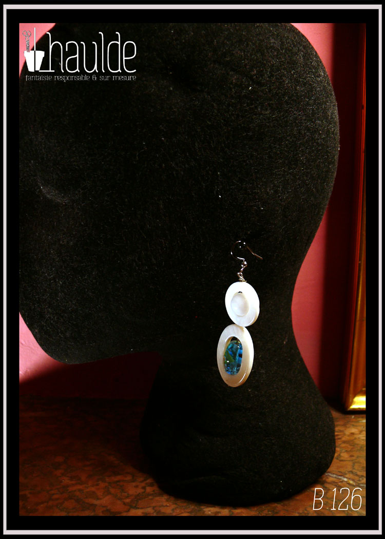 boucles d'oreilles montées sur crochet d'acier et composées d'une ellipse de nacre blanc avec en son centre une perle en verre de Bohème identique à celles du collier, surmontée d'un cercle de nacre avec en son centre une perle de jade blanc Vu de profil sur une tête de mannequin en velours noir