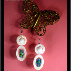 boucles d'oreilles montées sur crochet d'acier et composées d'une ellipse de nacre blanc avec en son centre une perle en verre de Bohème identique à celles du collier, surmontée d'un cercle de nacre avec en son centre une perle de jade blanc La paire vue suspendue à un papillon en dentelle d'acier doré