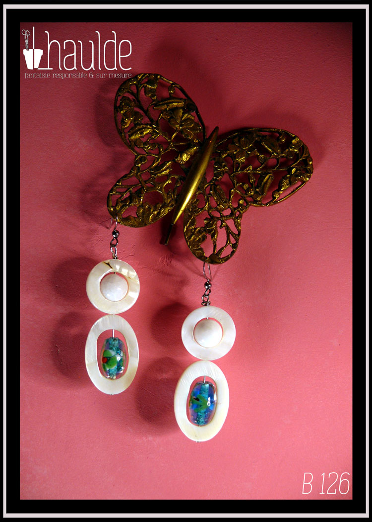 boucles d'oreilles montées sur crochet d'acier et composées d'une ellipse de nacre blanc avec en son centre une perle en verre de Bohème identique à celles du collier, surmontée d'un cercle de nacre avec en son centre une perle de jade blanc La paire vue suspendue à un papillon en dentelle d'acier doré