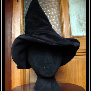 Chapeau de sorcière à haut bout pointu et large rebord en velours noir Vu porté par une tête de mannequin