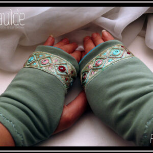 Mitaines en jersey vert d'eau avec un galon brodé au niveau des phalanges, il mesure 3 cm de large, fond vert turquoise pâle, losanges en fil doré avec au centre des cercles roses ou bleus ou rouge bordeaux et entre les pointes des losanges de petits sequins ronds dorés et des points de la même couleur que les cercles Vue de la paire vue de dessus, portée