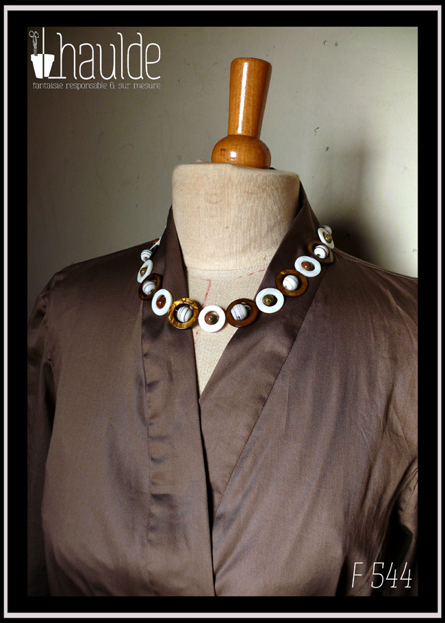 Détail de l'encolure avec un collier en cercles de nacre et pierres naturelles (référence B 127) Chemisier manches longues col châle croisé noué dans le dos en satin de coton marron glacé