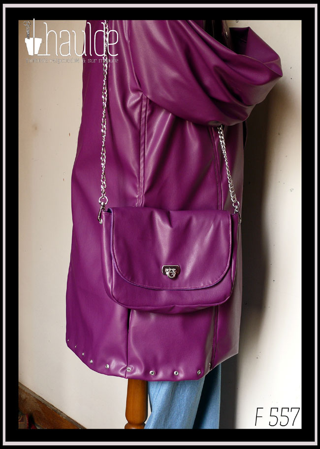 Petit sac à bandoulière chaine d'acier en simili cuir violet, rabat arrondi, fermoir pivotant en acier Vu sur un mannequin de couture portant une veste dans la même matière