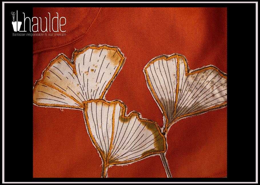 détail de l'appliqué en bas du pan devant droit Le motif ginkgo est découpé et cerné d'ocre