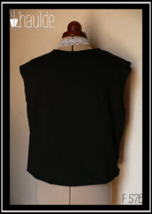 Haut sans manche en french terry noir, ras du cou, façon blouse avec un bas élastiqué qui renforce l'aspect bouffant vu de face sur un mannequin de couture