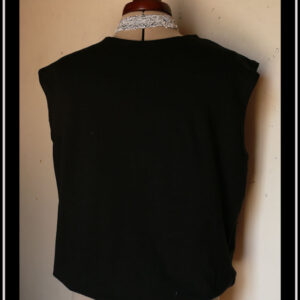 Haut sans manche en french terry noir, ras du cou, façon blouse avec un bas élastiqué qui renforce l'aspect bouffant vu de face sur un mannequin de couture