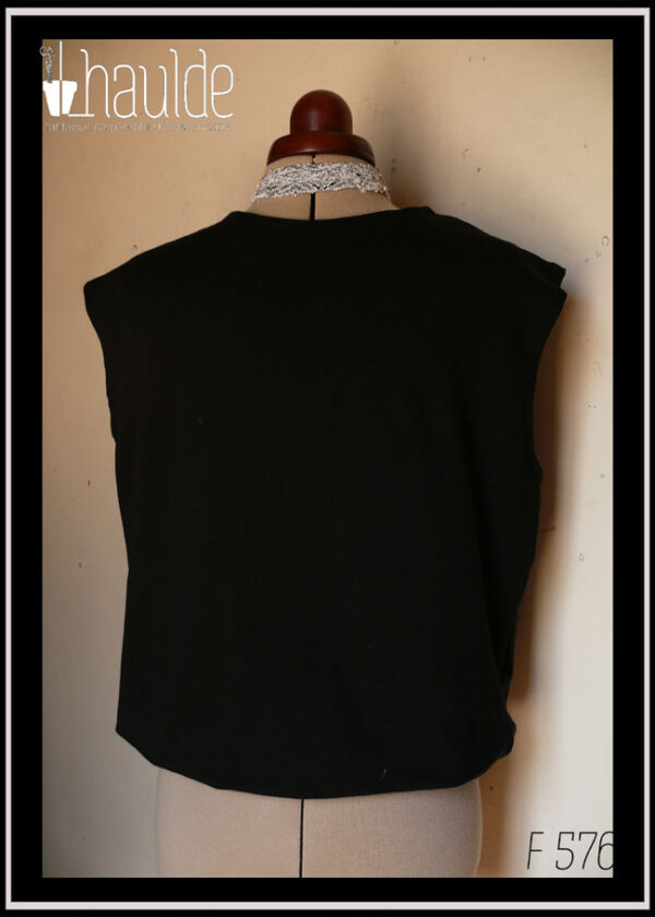 Haut sans manche en french terry noir, ras du cou, façon blouse avec un bas élastiqué qui renforce l'aspect bouffant vu de face sur un mannequin de couture