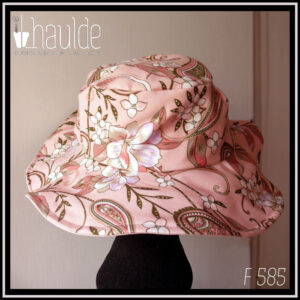chapeau à large bord en sergé rose pâle dessous, imprimé paisley et fleurs sur fond rose pâle dessus Vue de dos sur une tête de mannequin