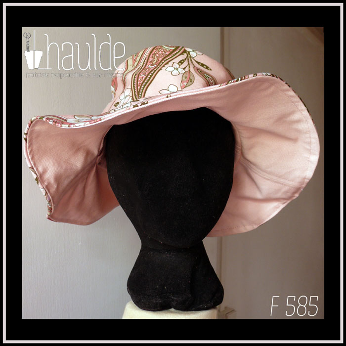 chapeau à large bord en sergé rose pâle dessous, imprimé paisley et fleurs sur fond rose pâle dessus Vue de face sur une tête de mannequin