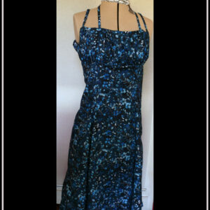 Robe mi-longue à fines bretelles (une paire classique, réglable et une paire nouée autour du cou), buste plissé, taille ajustée, jupe ample, en popeline bleu nuit imprimé petite fleurs et végétaux délicats en dégradé de bleu jean Vue de face sur un mannequin de couture