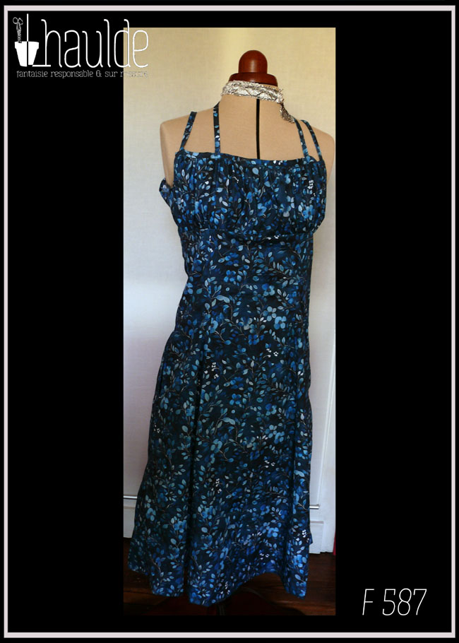 Robe mi-longue à fines bretelles (une paire classique, réglable et une paire nouée autour du cou), buste plissé, taille ajustée, jupe ample, en popeline bleu nuit imprimé petite fleurs et végétaux délicats en dégradé de bleu jean Vue de face sur un mannequin de couture