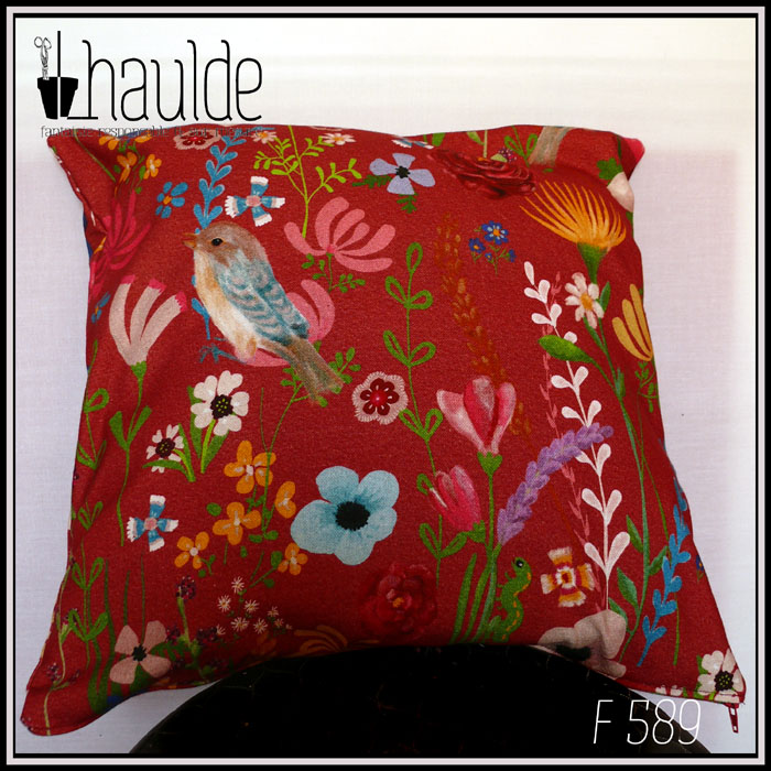 Coussin fond rouge foncé, imprimé oiseaux et fleurs, dans un style rappelant des illustrations