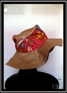 Chapeau à large bord en sergé beige, dessus en tissu rouge imprimé fleurs Vu de profil sur une tête de mannequin
