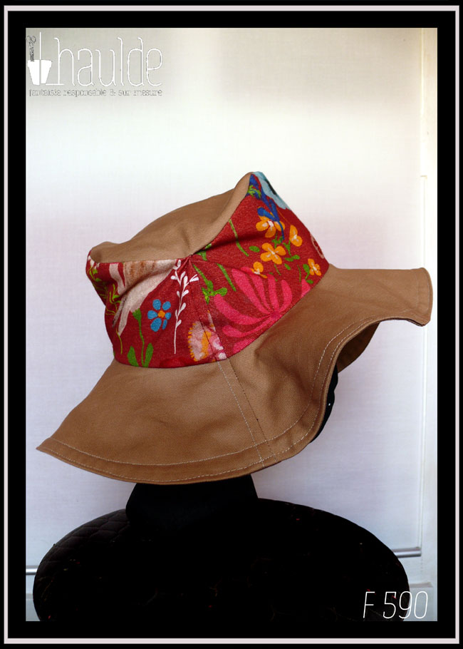 Chapeau à large bord en sergé beige, dessus en tissu rouge imprimé fleurs Vu de profil sur une tête de mannequin