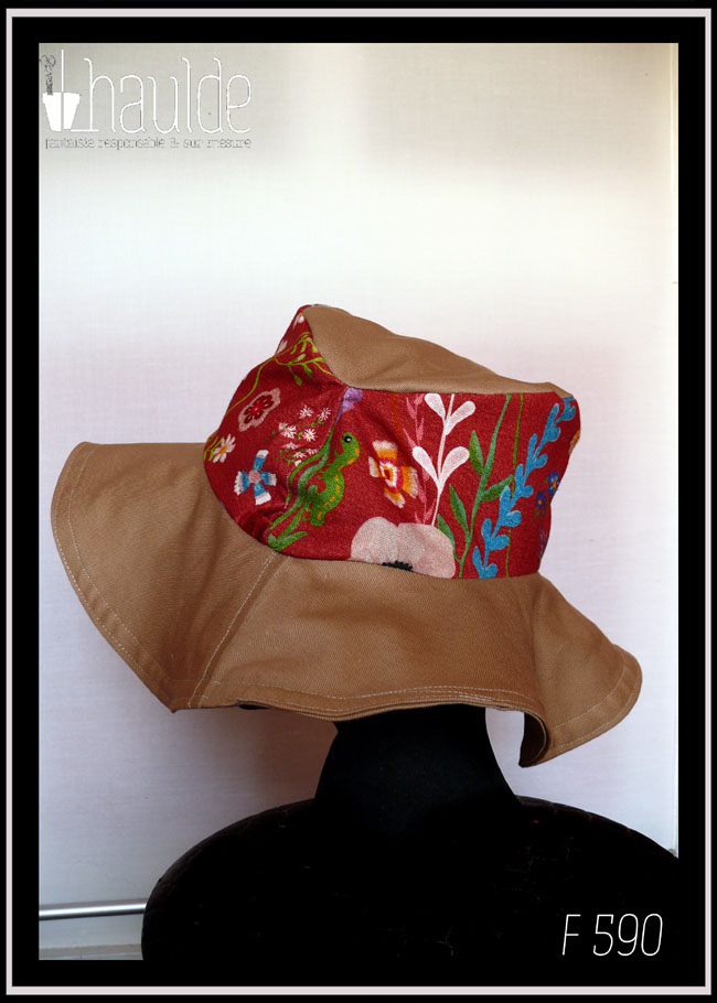 Chapeau à large bord en sergé beige, dessus en tissu rouge imprimé fleurs Vu de profil sur une tête de mannequin