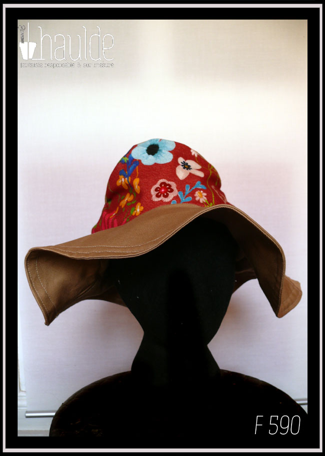 Chapeau à large bord en sergé beige, dessus en tissu rouge imprimé fleurs Vu de face sur une tête de mannequin