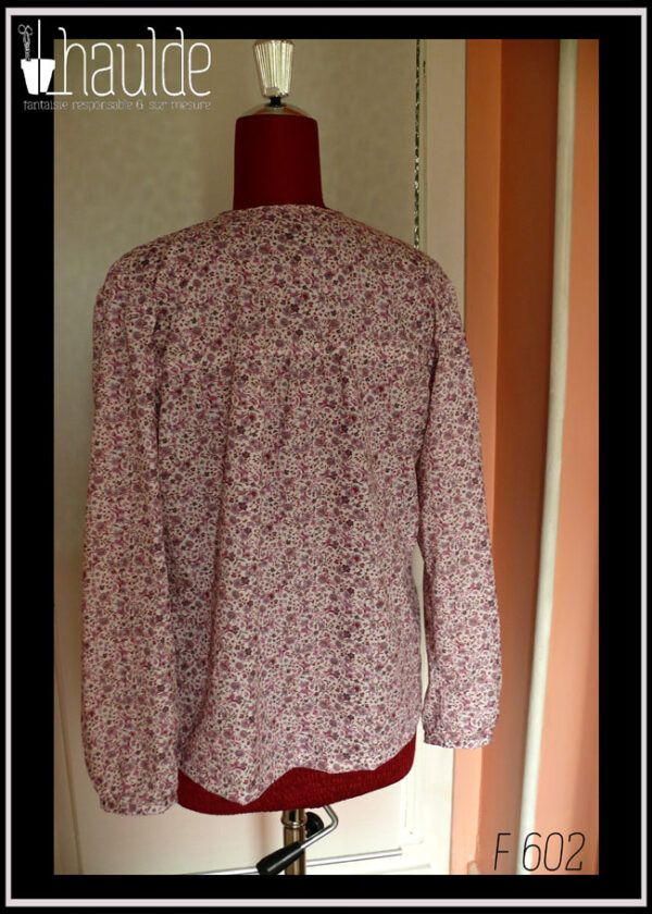 Blouse col V échancré, manches longues en popeline blanche imprimé petites fleurs mauves et roses Vue de dos sur un mannequin de couture